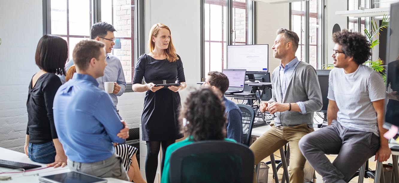 Creative professionals standing in office discussing Creative Jobs in New York